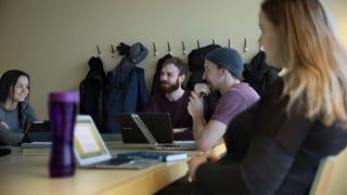 Four history students sitting around at table in a classroom