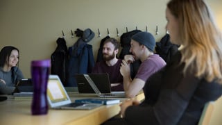Flera historiestudenter sitter vid ett bord och diskuterar vid ett seminarium