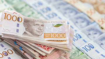 En bunt tusenlappar och andra svenska sedlar i bakgrunden
