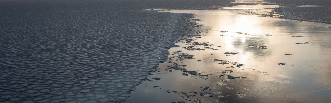 Solen lyser i en isränna från ett fartyg