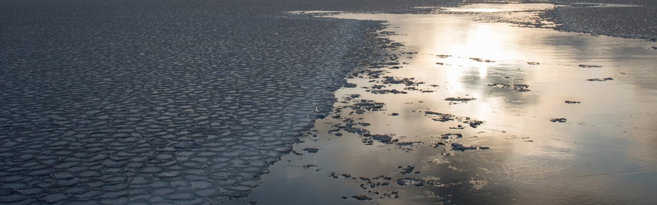 Solen lyser i en isränna från ett fartyg
