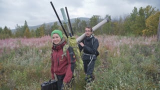 Forskare bär på utrustning för fältstudier i Lapplandsfjällen.