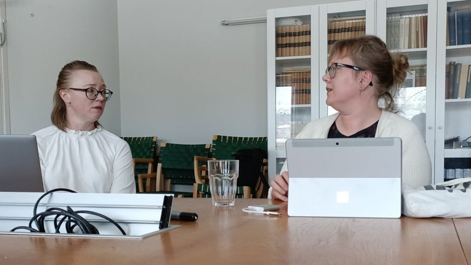 Linda Lundmark och Hanna Lempinen diskuterar vid ett bord