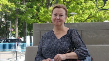 Maria Nilsson poserar framför en skulptur på en knuten revolver utanför FN-skrapan i New York