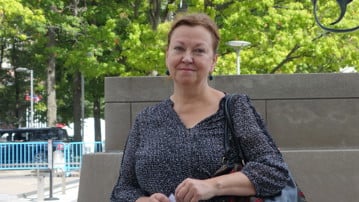 Maria Nilsson poserar framför en skulptur på en knuten revolver utanför FN-skrapan i New York