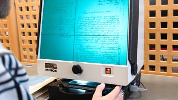 Person använder en mikroficheläsare