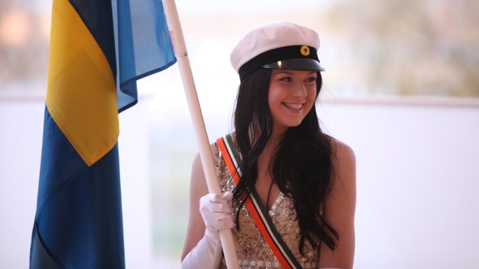 Studentmarskalk som håller en flagga vid Vårpromotionen.
