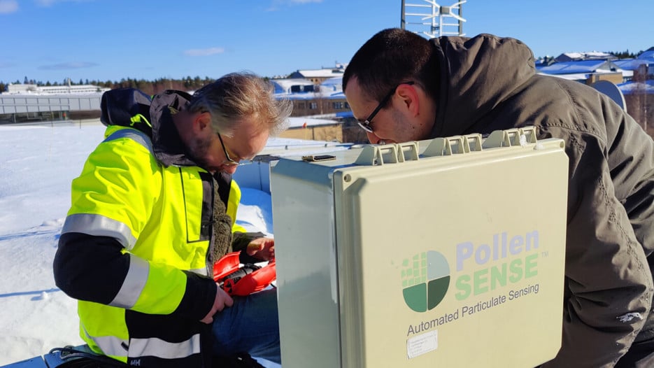 Två personer står böjda över verktyg och digitala instrument.