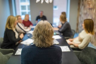 Personer i möte vid ett konferensbord.