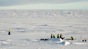 En flygbild som visar en grupp forskare som arbetar på is i Arktis