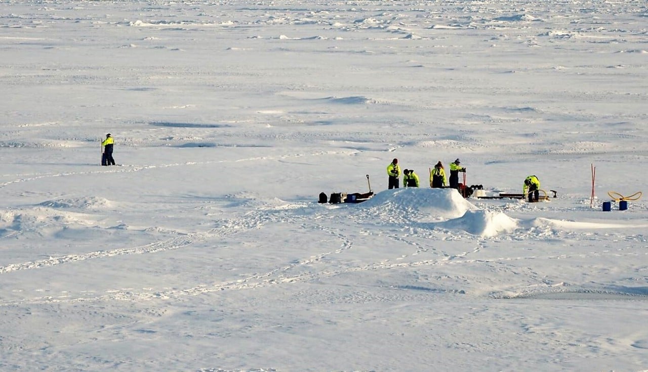 En flygbild som visar en grupp forskare som arbetar på is i Arktis