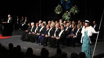 Studentmarskalkar står på scenen vid Årshögtidens ceremoni.
