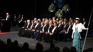 Studentmarskalkar står på scenen vid Årshögtidens ceremoni.