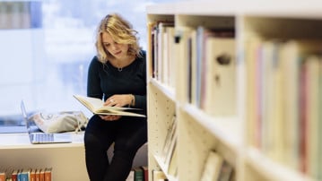 Bild på student på biblioteket