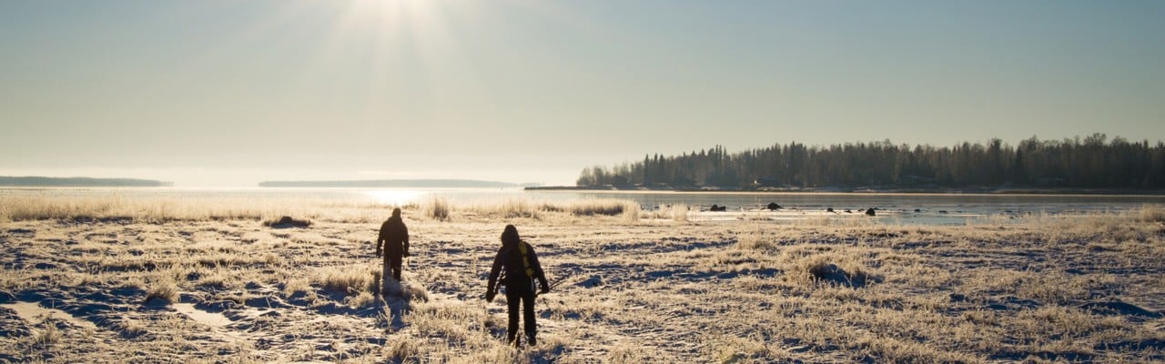 Två personer utforskar den vintriga naturen i Luleå.