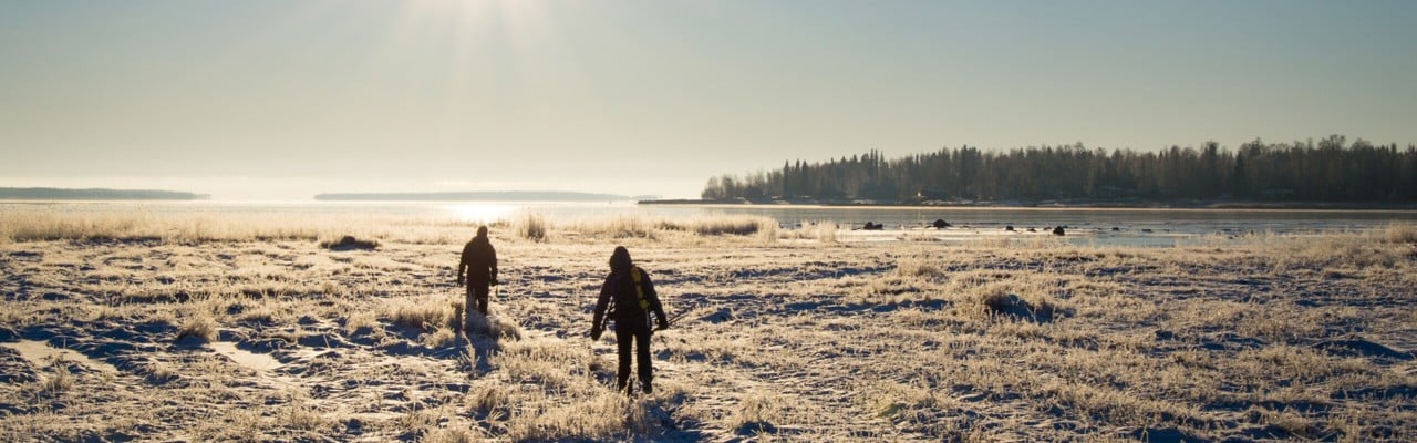 Två personer utforskar den vintriga naturen i Luleå.