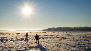 Två personer utforskar den vintriga naturen i Luleå.