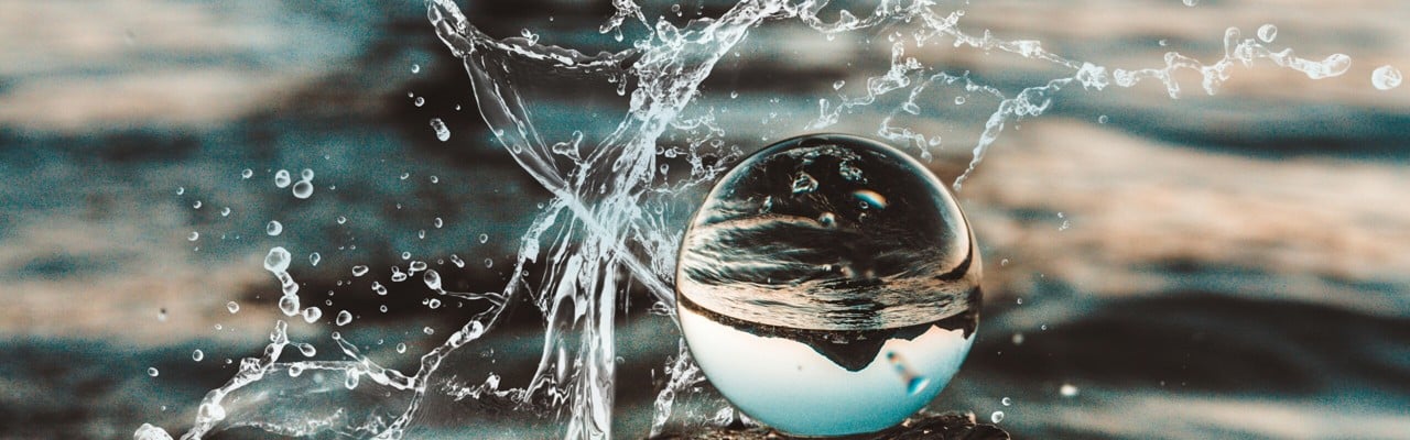 En vattenbubbla som reflekterar en kulle i bakgrunden