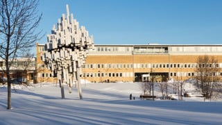 Vy över dammen mot Samhällsvetarhuset med statyn Norra skenet i förgrunden.