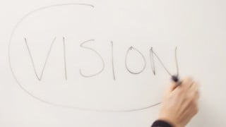 Bild på ordet vision skrivet på tavlan
