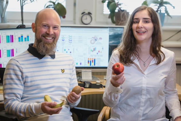 Researchers holding fruit in office. Umeå University.